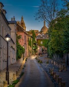 Explore a picturesque evening street in Montmartre, Paris, surrounded by historic architecture.
